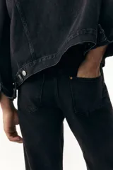 Pantalón de jean negro de corte recto y tiro medio, con cinco bolsillos y cierre de botón.