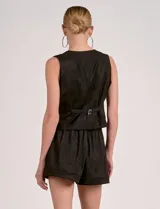 Chaleco color beige de estilo formal, con escote en V y cierre frontal de botones. Presenta bolsillos falsos a la altura de la cintura.