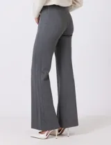 Pantalón wide leg color beige de tiro alto con cintura elastizada y costura central pespuntada a lo largo de la pierna.