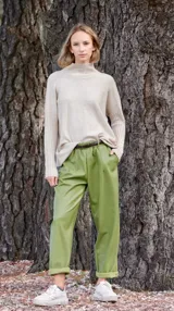 Pantalón babucha verde de cuerina con bolsillos laterales y cinturón fino marrón.