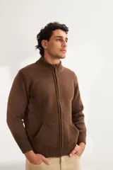 Campera de lana color crema, tejida con cierre delantero, cuello alto y bolsillos delanteros.