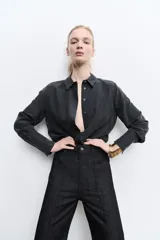 Pantalón de jean negro de tiro alto con trabillas en la cintura, corte bootcut y cinco bolsillos.