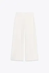 Pantalón blanco de tiro medio, cintura con elástico interior y pierna ancha.