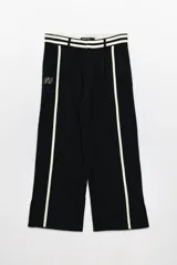 Pantalón sastrero negro de lino con pierna ancha, cintura alta con triple línea blanca y bordado blanco en la pierna izquierda.