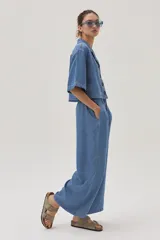 Pantalón de jean celeste de corte ancho, con cintura alta y lazo ajustable.
