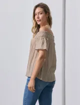 Blusa color beige de gasa bambula, marca Liv Los Ángeles. Escote recto con frunce y hombros descubiertos. Manga corta con detalles bordados.