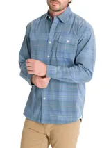 Camisa de franela de algodón orgánico a cuadros en tonos azul, gris y verde. Tiene cuello camisero, manga larga, un bolsillo en el pecho y cierre con botones.