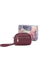 Monedero negro de simil cuero con correa para la mano, diseño práctico y compacto. Bolsillo principal con doble cierre, y un bolsillo frontal pequeño para llevar monedas.