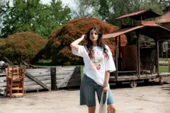 Remera blanca de algodón con cuello redondo y mangas cortas. Estampado frontal con diseño de cócteles y texto "Summer Babe Cocktail Club and Chill".