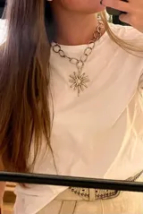 Collar plateado con cadena gruesa y dije en forma de sol.