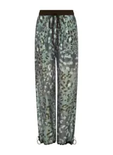 Pantalón de tiro alto confeccionado en tejido similar al lino con estampado animal, cintura elástica con cordón, cuatro bolsillos, banda lateral, bajos ajustables y acabado pespunteado.