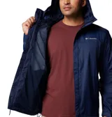 Campera impermeable Columbia Watertight II color verde oliva para hombre, con capucha ajustable, cierre frontal con cremallera, bolsillos laterales con cremallera, puños ajustables con velcro y dobladillo ajustable con cordón. Se puede guardar en su propio bolsillo. Cuenta con tecnología Omni-Tech™ que la hace impermeable y transpirable.