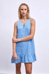 Vestido corto sin mangas, color celeste claro, con escote en V y un pequeño broche decorativo en la abertura frontal. Presenta un corte holgado tipo babydoll con bolsillos laterales y un ruedo con volado.