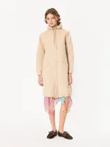 Parka larga color beige con capucha y cierre frontal con cremallera. Tiene bolsillos delanteros y estampado de hongos en la espalda.