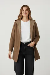 Saco largo de tejido de punto color camel, con capucha y bolsillos frontales. El interior de la capucha y el borde frontal tienen un estampado geométrico en tonos beige y marrón.