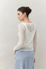 Top de manga larga color blanco, de tejido translúcido y texturizado, ajustado al cuerpo.