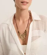 Collar corto con cordón marrón ajustable y colgantes de peces martillados en color dorado envejecido.