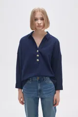 Blusa blanca holgada de poliéster con cuello camisero y mangas largas.