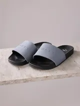 Sandalias tipo ojotas Rusty Burkes26 para hombre, color gris con base negra y logo de la marca en la tira.