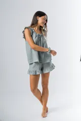 Conjunto de pijama de algodón estampado con flores, compuesto por una musculosa de escote recto con frunces y un short con elástico en la cintura y volados en el ruedo.