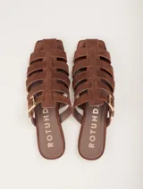 Sandalias planas de cuero color marrón con diseño de tiras entrecruzadas y hebilla lateral ajustable.