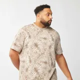 Camiseta de manga corta color beige con estampado de hojas en tonos blanco y marrón.