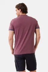 Remera de manga corta color azul grisáceo con cuello mao y tapeta de botones. Los puños de las mangas y el cuello son de color azul marino contrastante. Presenta un pequeño logo bordado en el pecho.