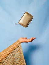 Billetera dorada de cuero con cierre, capacidad para tarjetas, billetes y monedas.