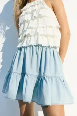 Minifalda celeste de denim con cintura elastizada y volados en el ruedo.