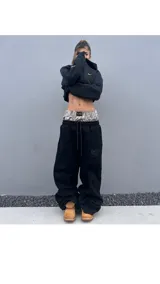 Zapatilla deportiva de estilo chunky, con múltiples capas superpuestas en tonos negros y grises con estampado camuflado tipo Real Tree. Presenta cordones gruesos y suela robusta.