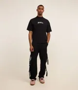 Pantalón cargo recto color negro, de sarga de algodón, con bolsillos laterales con hebillas y trabillas en la cintura.