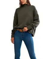 Suéter tejido de punto grueso color verde oliva, con cuello alto y calce oversized. Presenta costuras marcadas en los hombros y puños anchos.