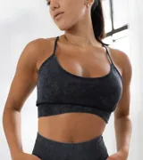Top deportivo negro con efecto lavado, breteles finos y espalda deportiva.