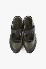 Zapato de cuero sintético color verde oliva y negro, con suela track blanca y tira de velcro en el empeine.