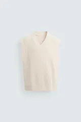 Chaleco de punto color crema con cuello en V y sisas.