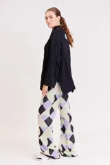 Pantalón de punto con estampado geométrico en tonos lila, verde y beige.
