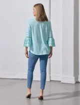 Blusa color celeste con escote en V, mangas largas acampanadas con detalle de crochet.
