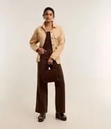 Pantalón wide leg color crudo, de sarga con tiro alto, trabillas, bolsillos delanteros y traseros, y costura vertical delantera.