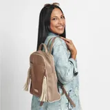 Mochila negra con textura tipo reptil, detalles en color camel y cierre con cremallera. Tiene un bolsillo frontal con cremallera y tiras decorativas con flecos.