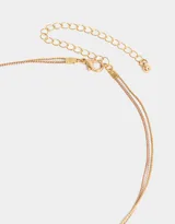 Collar corto multicadena con dijes de corazones en oro, oro rosa y plata.