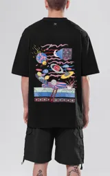 Remera negra de corte holgado con estampado en la espalda de un paisaje surrealista con planetas, lunas, escaleras y figuras geométricas.