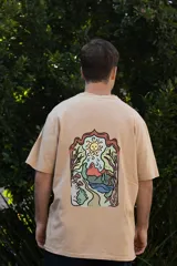 Remera color arena de algodón con cuello redondo y mangas cortas. Estampado frontal con tres hongos rojos y la palabra "Tuya" debajo.