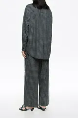 Pantalón largo de corte recto y tiro bajo, confeccionado en algodón con diseño de cuadrícula. Presenta bolsillos laterales en costura, bolsillos de parche en la parte trasera y cinturilla elástica posterior para un mejor ajuste.