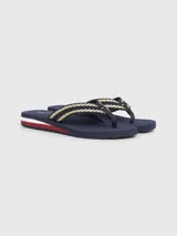 Ojotas Tommy Hilfiger color azul marino con tiras trenzadas en dorado y detalles distintivos de la marca.