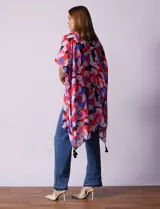 Kimono tejido con estampado floral multicolor y terminación de ruedo con borlas negras.