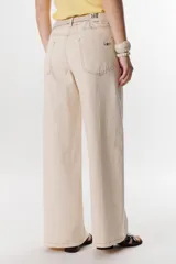 Jean de mujer, color azul oscuro, tiro alto, corte ancho y holgado (wide leg). Se caracteriza por pespuntes en zigzag visibles en los laterales y bolsillos.