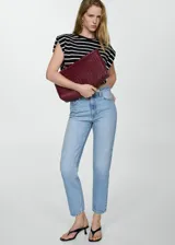 Pantalón de jean celeste de corte mom fit, tiro alto, cinco bolsillos y cierre con cremallera y botón.