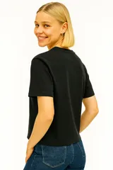Remera blanca de algodón con cuello redondo y mangas cortas. Estampado frontal con dibujo lineal de flores en un jarrón.