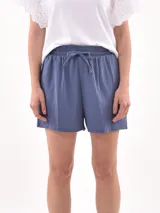 Short celeste de tejido arrugado con cintura elastizada y lazo de ajuste.