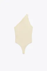 Body color crema de poliamida, con escote asimétrico y tirante ancho. Cierre inferior con botones a presión.